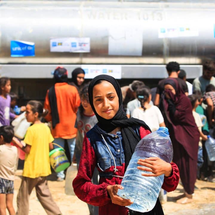 Dans la bande de Gaza, Malak, 14 ans, fait la queue pendant de longues heures pour avoir de l'eau potable. © UNICEF/UNI613724/El Baba