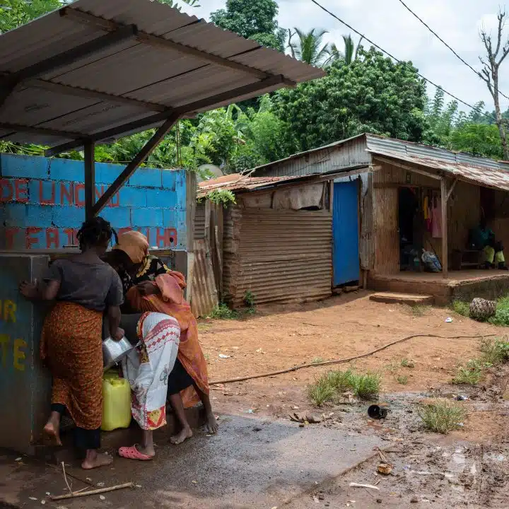 Des habitants et des enfants viennent chercher de l'eau potable avec des jerrycans à la borne-fontaine de Dzoumogne à Mayotte. (Photo Bastien Doudaine / Hans Lucas / Hans Lucas via AFP)