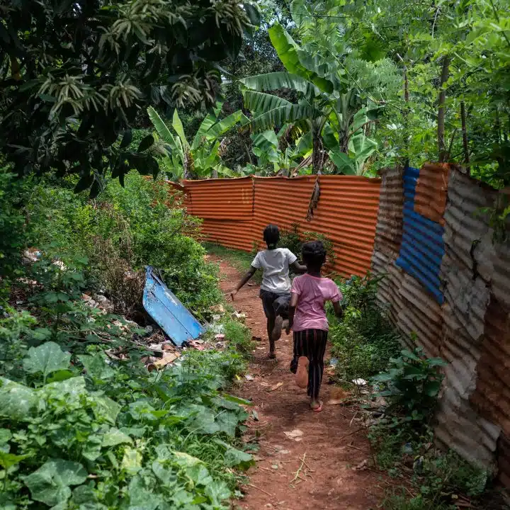 Des enfants courent dans une rue jonchée de détritus à Longoni, Mayotte. Ici, l'habitat précaire en tôle représente 39% des résidences principales recensées. En 2017, 95% des familles vivant dans ces cases ne disposaient pas d'installations sanitaires de base. (Photo Bastien Doudaine / Hans Lucas / Hans Lucas via AFP)