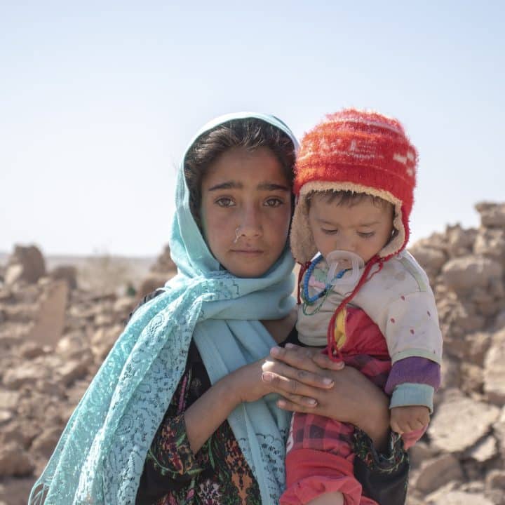 Le 10 octobre 2023, Zari, 10 ans, tient dans ses bras son frère Marv, 8 mois, après que leur maison a été détruite par le tremblement de terre dans le district de Zinda Jan, en Afghanistan. © UNICEF/UNI452497/Khayyam