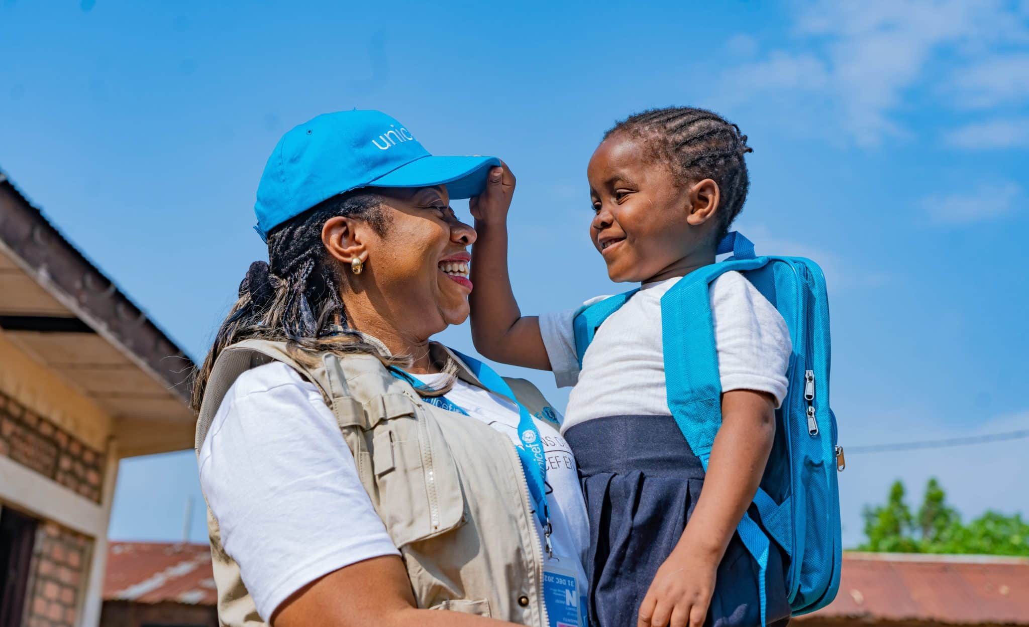 Le 12 octobre 2023, en RDC, Nkembo, 7 ans, joue avec Solange Nabintu Murhega, membre du personnel de l'UNICEF à Kinshasa. La petite fille vient de recevoir un kit scolaire de l'UNICEF. © UNICEF/UNI456462/Mulala