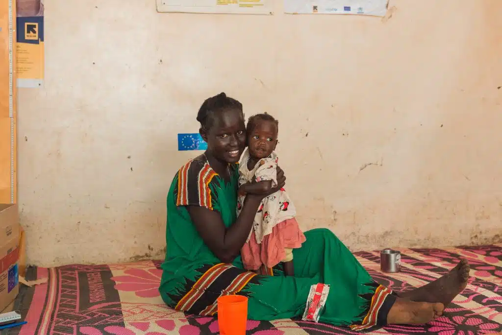 Dans le camp de réfugiés de Kakuma, au Kenya Sabina Naboi, mère d'Analia Wally, donne à sa fille des aliments thérapeutiques. Au Kenya, Six saisons de sécheresse sévère, accélérée par le changement climatique, ont eu un impact négatif sur l'état nutritionnel des habitants du comté de Turkana. © UNICEF/UNI431381/Kidero