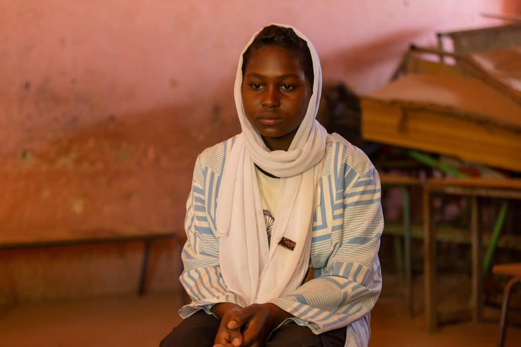 Walaa, 15 ans, est assise dans une salle de classe vide de l'espace d'apprentissage sécurisé Alshargia, soutenu par l'UNICEF, dans l'État de Kassala.© UNICEF/UNI546790/Elfatih