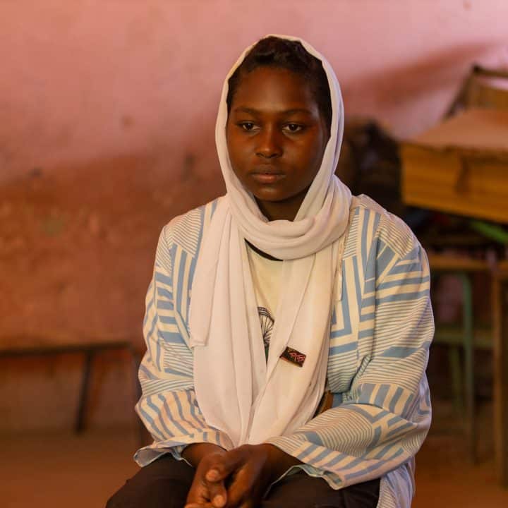 Walaa, 15 ans, est assise dans une salle de classe vide de l'espace d'apprentissage sécurisé Alshargia, soutenu par l'UNICEF, dans l'État de Kassala.© UNICEF/UNI546790/Elfatih