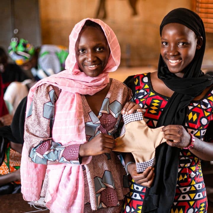Fatoumata Diallo, 17 ans, et Mampi dabou, 16 ans, montrent une serviette hygiène faite à la main. ©UNICEF/UNI560599/Keïta