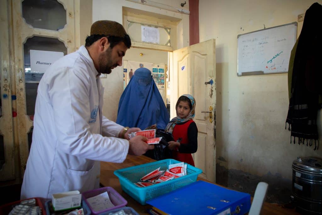 En février 2024, Narges attend de recevoir des aliments thérapeutiques prêts à l'emploi (RUTF) pour sa fille Hasenat, qui est prise en charge pour malnutrition au centre de santé de base de Nahri Shahi, dans la province de Jalalabad, en Afghanistan. © UNICEF/UNI540605/Haya Burhan