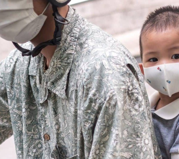 Bui Hoang The Bao, 3 ans, porte un masque lorsqu'il se déplace en moto avec sa famille à Ha Noi. ©UNICEF/UNI565989/Pham Ha Duy Linh