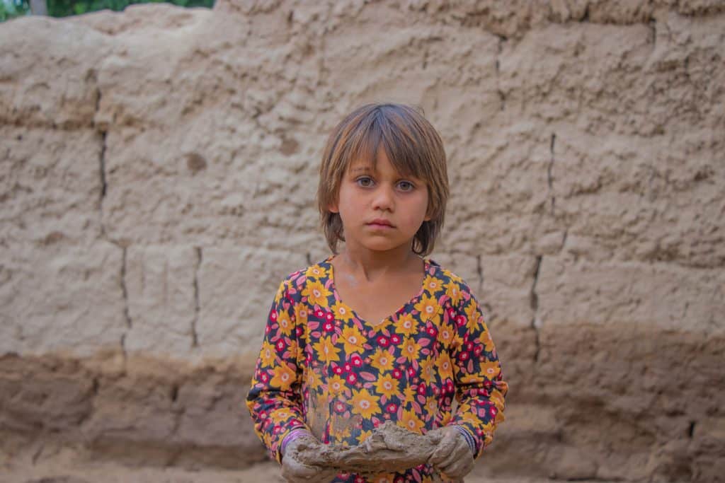 Le 16 mai 2024, Somaya, 7 ans, se tient dans la boue dans la province de Baghlan, en Afghanistan. Sa famille, a été touchée par les crues soudaines dans le nord de l'Afghanistan. © UNICEF/UNI577376/Khayyam