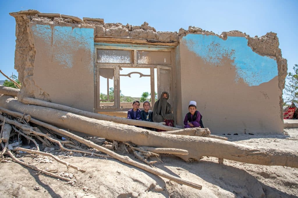 Le 3 juin 2024, Bibi Nar, est assise avec ses enfants à l'extérieur de leur maison détruite à la suite des crues qui ont touché la province de Baghlan, dans le nord de l'Afghanistan. © UNICEF/UNI586033/Musadiq