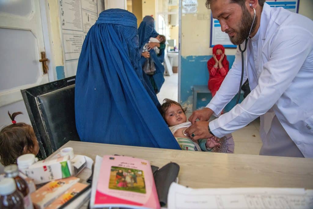 Le 3 juin 2024, à la suite d'importantes inondations dans la province de Baghlan, au nord de l'Afghanistan, le Dr Mohammed Nasir s'occupe de Rojan, 5 mois, dans un dispensaire soutenu par l'UNICEF.© UNICEF/UNI586038/Musadiq