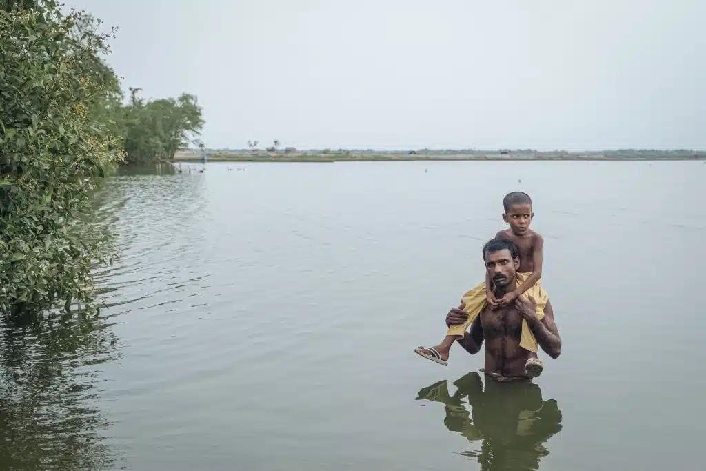 Sirajul traverse une zone inondée avec sa fille de 6 ans, sur ses épaules. Les inondations dévastatrices qui ont frappé le Bangladesh en mai 2019, ont emporté leur maison. © UNICEF/UNI424978/Sokhin