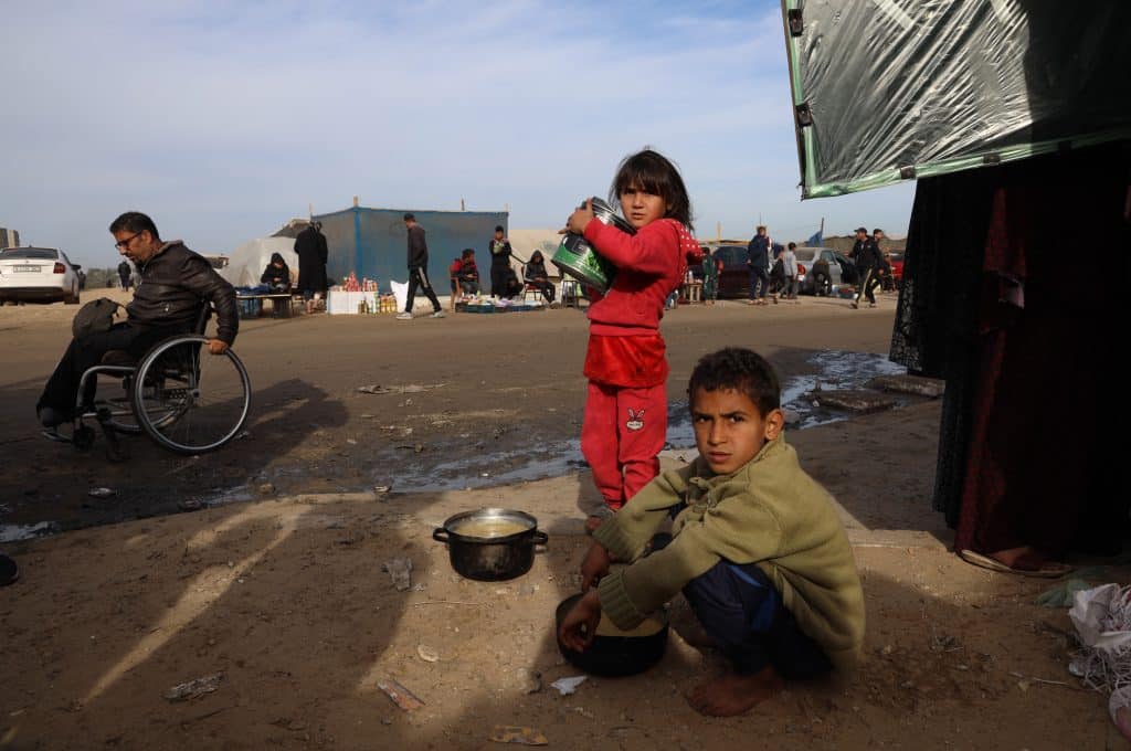 Des enfants déplacés cherchent de la nourriture près des tentes où ils sont déplacés avec leurs familles, dans la ville de Rafah, au sud de la bande de Gaza. © UNICEF/UNI521740/El Baba