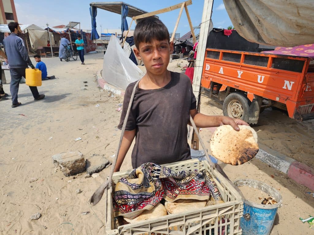 Youssef, 13 ans, rapporte du pain pour sa famille à al-Mawasi, dans le sud de la bande de Gaza. © UNICEF/UNI577081/Media Clinic