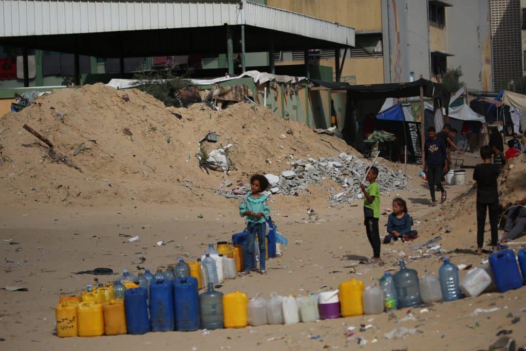 Des enfants recueillent de l'eau dans la ville de Khan Younis, dans le sud de la bande de Gaza. La majorité des systèmes d'approvisionnement en eau est hors service à cause du manque de carburant, de la situation sécuritaire et des dommages subis. © UNICEF/UNI580062/El Baba