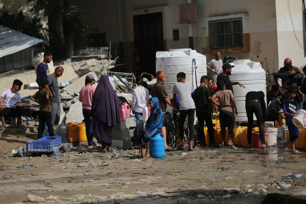 Des enfants recueillent de l'eau dans la ville de Khan Younis, dans le sud de la bande de Gaza. La majorité des systèmes d'approvisionnement en eau est hors service à cause du manque de carburant, de la situation sécuritaire et des dommages subis. © UNICEF/UNI580066/El Baba