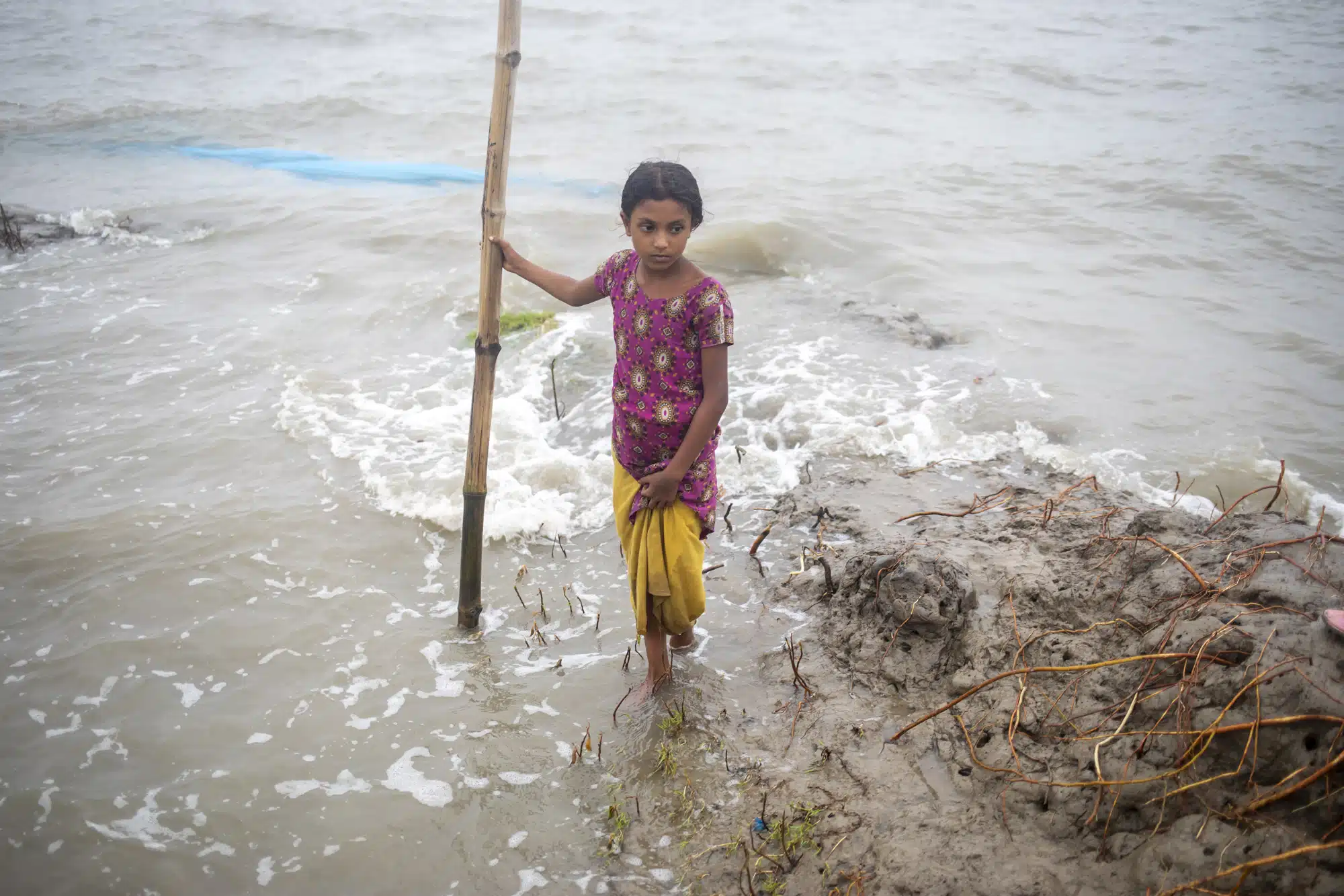 Le 28 mai 2024, au Bangladesh, Sumaiya, 10 ans, tente de traverser une route inondée pour se réfugier chez sa tante. © UNICEF/UNI583162/Satu