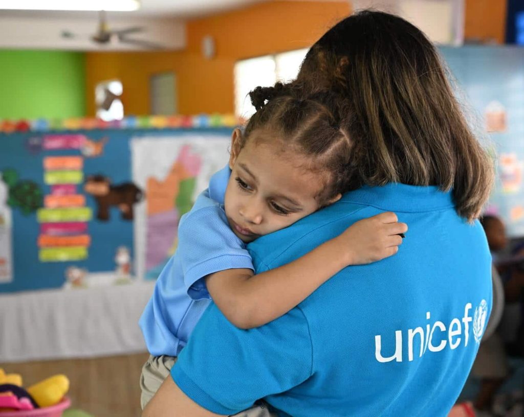 Un membre du personnel de l'UNICEF est avec un enfant dans une école maternelle à Belize City, la plus grande ville du Belize. © UNICEF/UNI594328/Dejongh