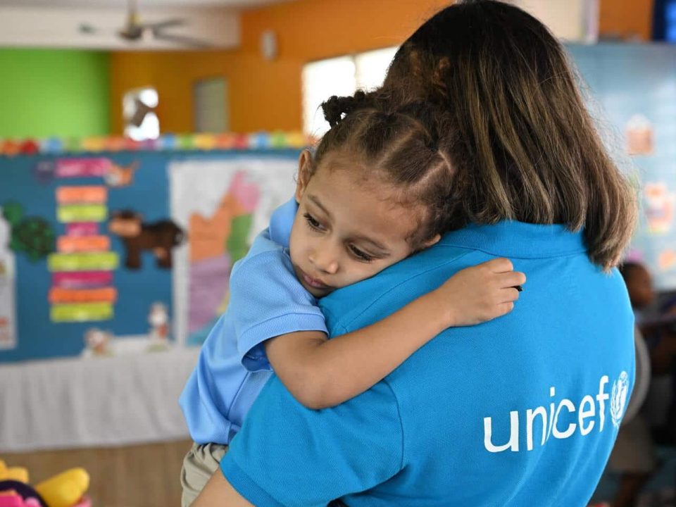 Un membre du personnel de l'UNICEF est avec un enfant dans une école maternelle à Belize City, la plus grande ville du Belize. © UNICEF/UNI594328/Dejongh