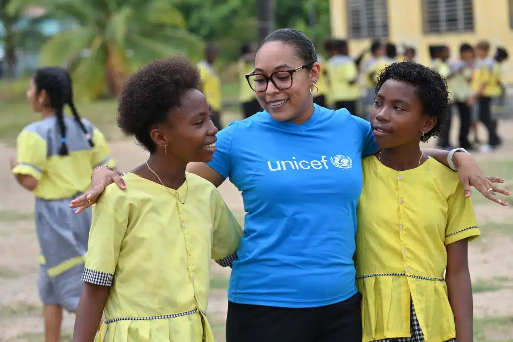 Un membre du personnel de l'UNICEF discute avec des filles de l'école primaire Gulisi de Dangriga, dans le sud du Belize. L'UNICEF a travaillé avec cette école pour soutenir l'éducation bilingue des enfants. © UNICEF/UNI594407/Dejongh