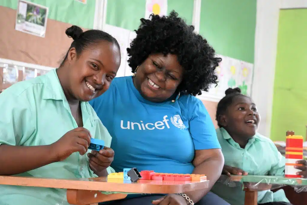 Phyllis, une jeune fille de 16 ans, est avec un membre du personnel de l'UNICEF, à l'école primaire Stella Maris de Belize City, la plus grande ville du Belize. Cette école accueille des enfants handicapés. L'UNICEF a apporté son soutien à la mise en place d'un programme spécial visant à enseigner aux élèves les compétences nécessaires à l'apprentissage d'un métier. © UNICEF/UNI596007/Dejongh