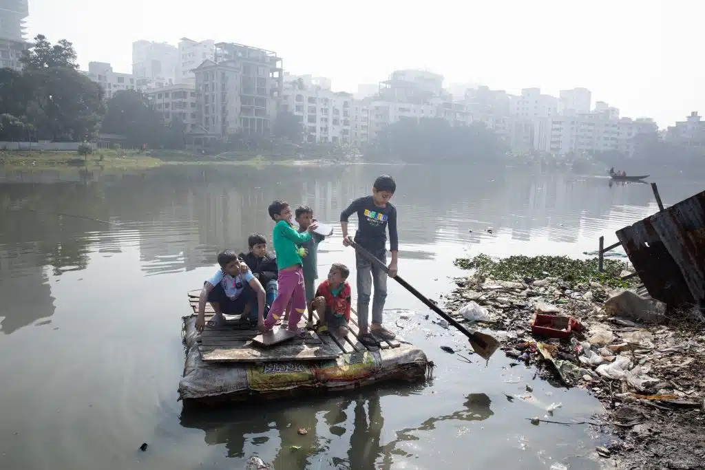 Le 28 janvier 2024, des enfants se tiennent sur un radeau sur le lac pollué de Banani dans le bidonville de Korail à Dhaka, au Bangladesh. © UNICEF/UNI526085/Mawa