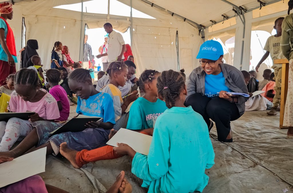 Le 9 juillet 2024, Nasra Islan, coordinatrice de programme de l'UNICEF, interagit avec des enfants dans l'espace ami des enfants du refuge de Minah Al Berih, qui abrite désormais des familles déplacées dans l'État de Gedaref au Soudan.© UNICEF/UNI610765/Rajab