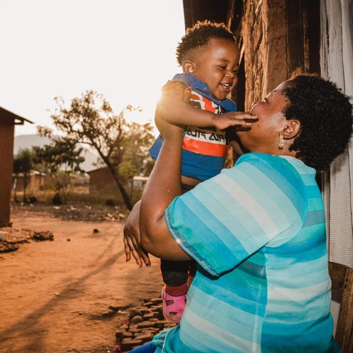 Gabriel, 1 an, joue avec sa mère Sarah à l'extérieur de leur maison à Kamanyola, dans la province du Sud-Kivu, en République démocratique du Congo. Le petit garçon a survécu à la mpox grâce à une prise en charge rapide à l'hôpital de Kamanyola, soutenu par l'UNICEF. © UNICEF/UNI624795/Benekire