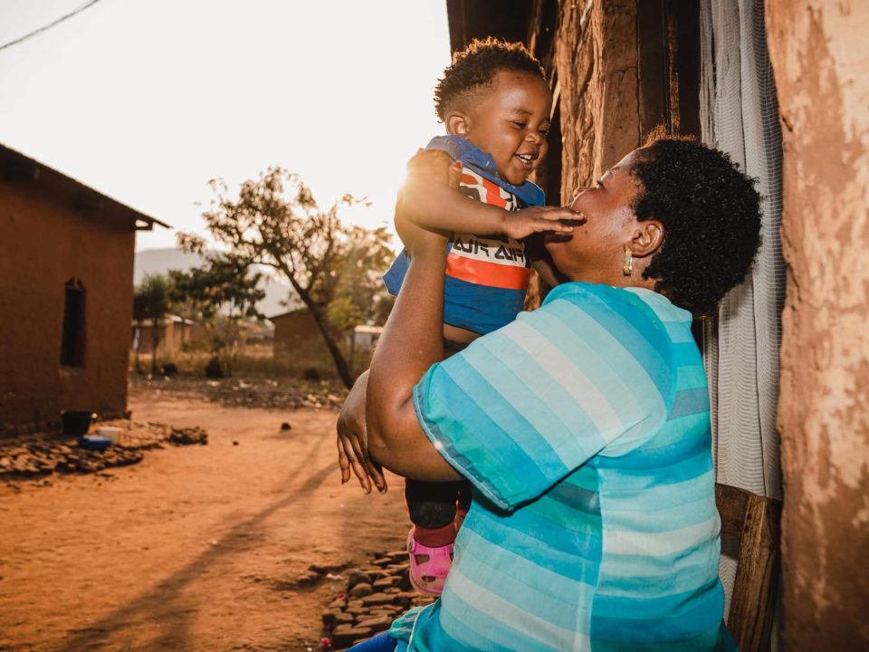 Gabriel, 1 an, joue avec sa mère Sarah à l'extérieur de leur maison à Kamanyola, dans la province du Sud-Kivu, en République démocratique du Congo. Le petit garçon a survécu à la mpox grâce à une prise en charge rapide à l'hôpital de Kamanyola, soutenu par l'UNICEF. © UNICEF/UNI624795/Benekire