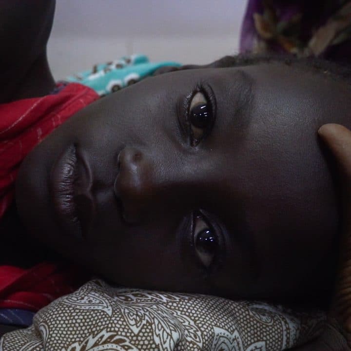 Le 10 août, Narmin est allongée sur un lit d'hôpital à Khartoum, où elle est soignée pour une blessure. © UNICEF/UNI625332/Isamaldeen