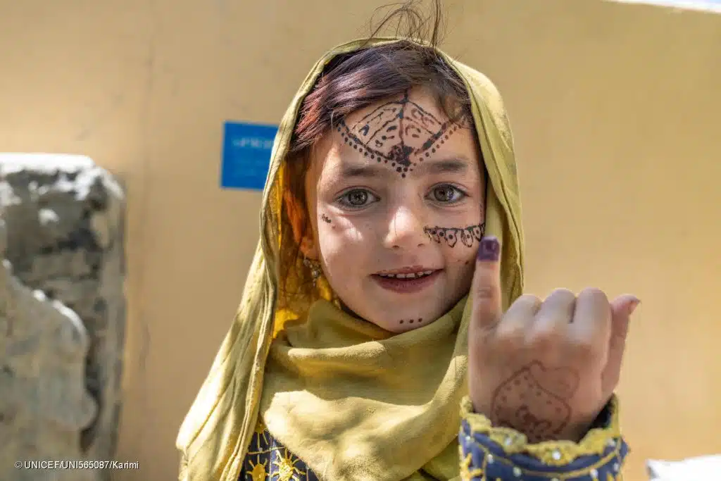 Une fillette de la province de Khost, dans le sud-est de l'Afghanistan, montre son doigt marqué après avoir été vaccinée contre la polio. © UNICEF/UNI565087/Karimi