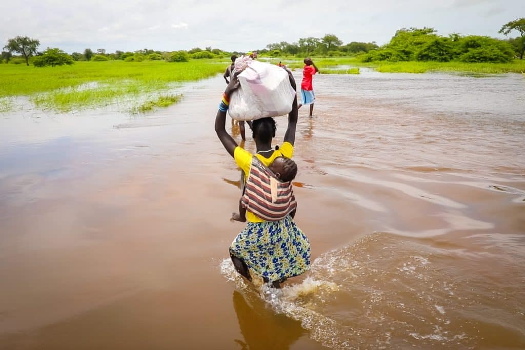 Les récentes inondations dans la région de Gambella, en Éthiopie, ont touché plus de 30 000 personnes, comme cette mère qui tente désespérément de traverser la rivière en crue en portant son bébé sur le dos, le 09/09/2024. © UNICEF/UNI640940/Pouget 