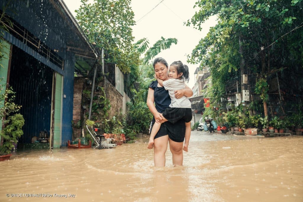 Une maman porte sa fille, suite au passage du typhon Yagi qui a ravagé le Vietnam le 7 septembre 2024. © UNICEF/UNI642138/Do Khuong Duy