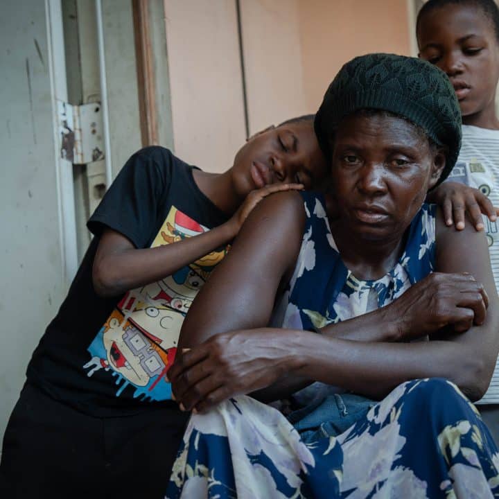 Evens et Iveneson, 9 ans, avec leur mère Guetty, sur le balcon du centre pour déplacés où ils résident actuellement, le 26 mai 2024. ©UNICEF/UNI582661/Le Lijour