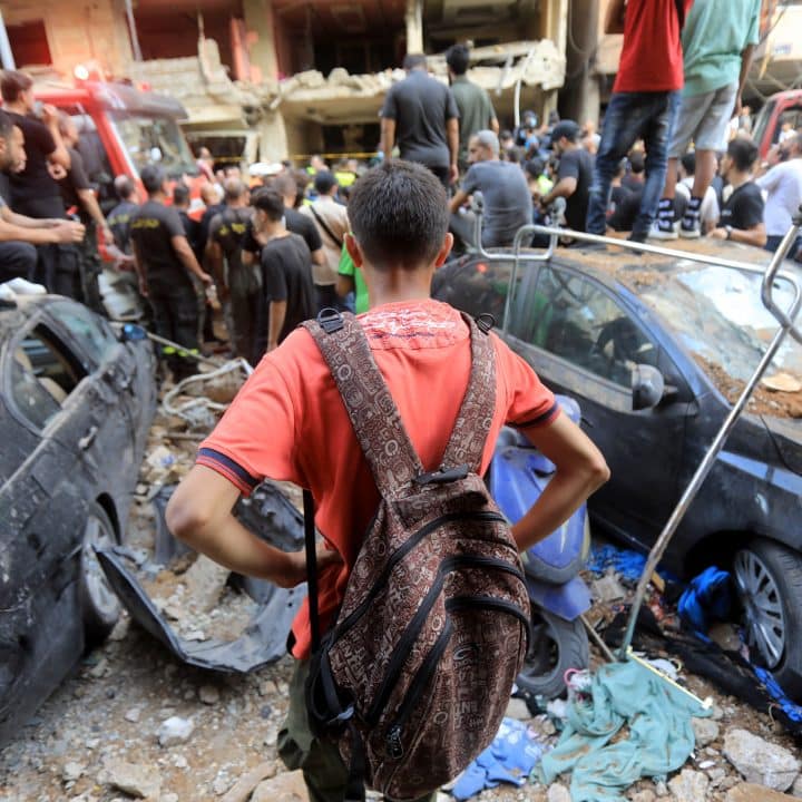 Un enfant observe les équipes chargées de déblayer les décombres d'un site détruit dans la banlieue sud de Beyrouth. © UNICEF/UNI649018/al Mussawir - Ramzi Haidar