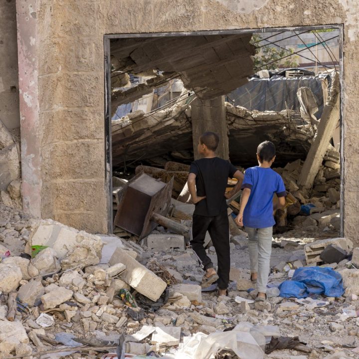 Des enfants du camp de réfugiés de Jénine en Cisjordanie regardent les abris détruits lors des récentes opérations militaires. © UNICEF/UNI671476/Izhiman