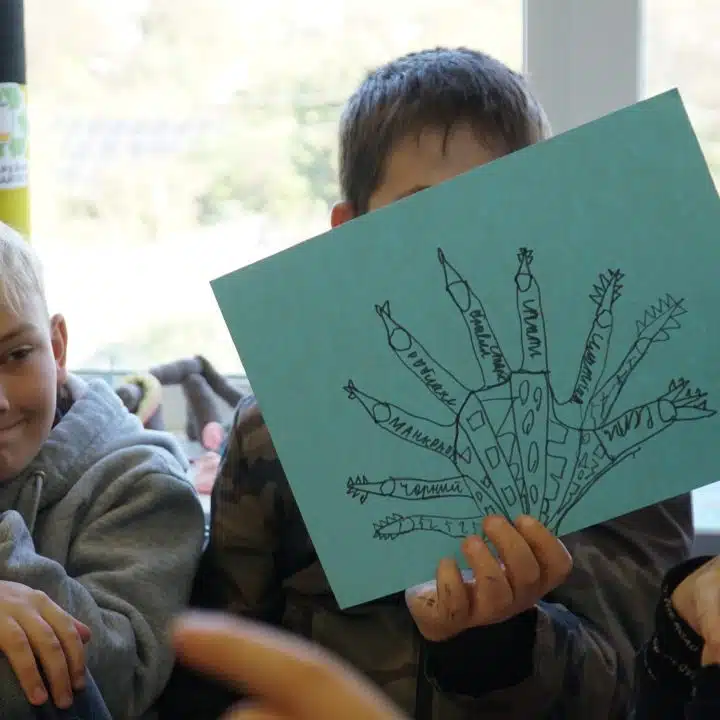 Un enfant montre son dessin, suite à une activité de groupe dans un Espace ami des enfants à Pidhorodnie (DNIPRO) en Ukraine. 24/10/2024 © UNICEF/Ihor Polianskyi