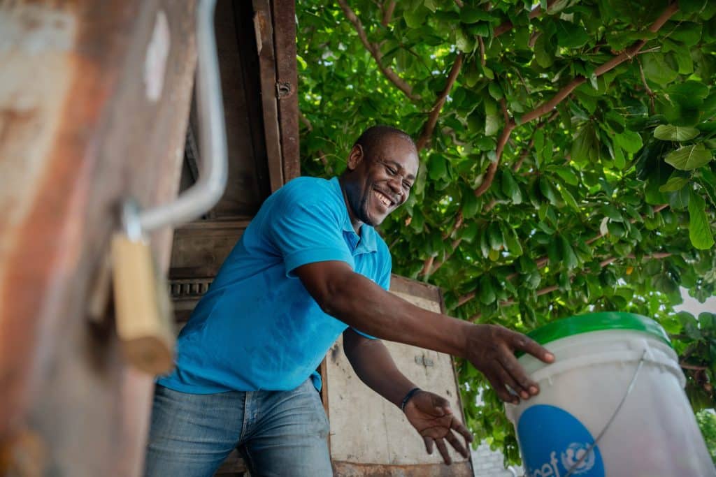 Le 27 mai 2024, Rwoodmayer St-fleur, responsable du programme WASH pour l'UNICEF Haïti, vide le camion transportant les kits d'hygiène destinés aux familles touchées par la tornade dans le Bassin Bleu. © UNICEF/UNI582678/Le Lijour