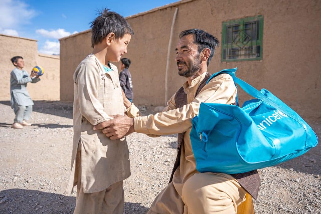 Le 2 décembre 2024, Mohammed Zahir, un agent de santé local qui travaille avec l'appui de l'UNICEF, s'entretient avec un enfant dans le village de Shahper, en Afghanistan. © UNICEF/UNI702572/Naftalin