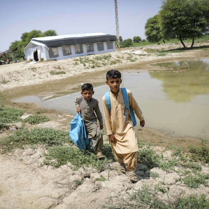 Le 7 septembre 2022, Daniyal Ahmad (8 ans) et son frère Hakim Ahmad (6 ans) rentrent chez eux après avoir suivi leur cours dans un centre d'apprentissage temporaire (TLC) soutenu par l'UNICEF dans le village d'Allah Dina Channa, dans la province du Baloutchistan, au Pakistan. ©UNICEF/UN0701854/Zaidi