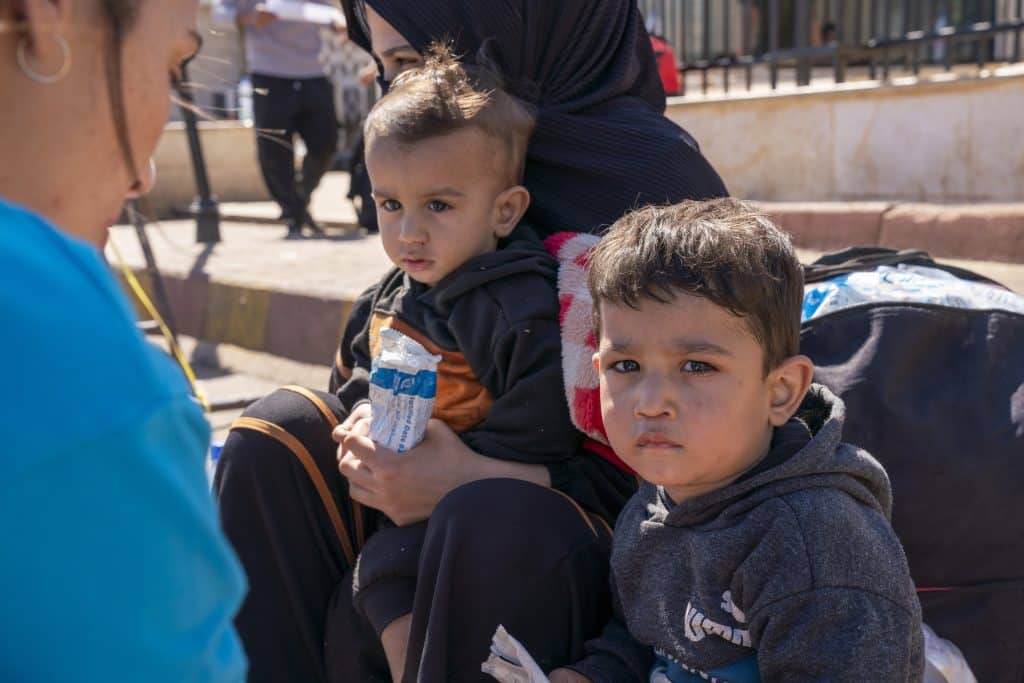 Le 5 octobre 2024, Ibrahim, 3 ans, et Ahmad, 1 an, sont assis avec leur mère à la frontière syrienne, après avoir fui l'escalade des violences au Liban. © UNICEF/UNI658536/Al-Asadi