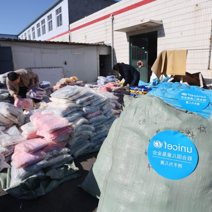 Des travailleurs emballent des vêtements d'hiver pour jeunes enfants préparés par l'UNICEF dans un entrepôt de Qingdao, dans la province de Shandong, en Chine, le 15 janvier 2025. © UNICEF/UNI719373/He Yi